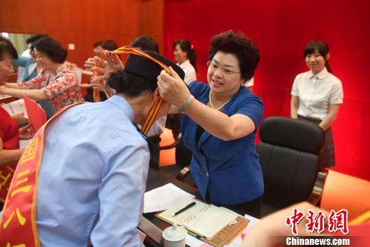 图为福建省妇联主席吴洪芹为全国三八红旗手颁奖。 吕明 摄 图为福建省妇联主席吴洪芹为全国三八红旗手颁奖。 吕明 摄