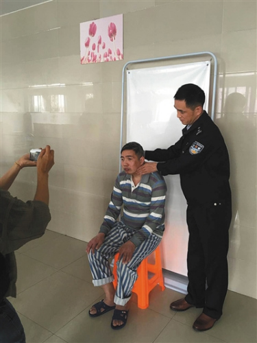 户籍民警帮助流浪者调整拍照姿势。 户籍民警帮助流浪者调整拍照姿势。