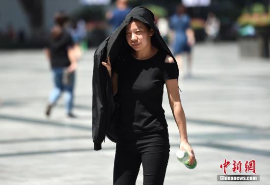 5月17日,重庆气温升至30℃以上,市民将随身衣物顶在头上遮挡烈日。周毅 摄 5月17日,重庆气温升至30℃以上,市民将随身衣物顶在头上遮挡烈日。周毅 摄