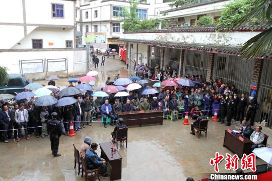 虽然下着大雨,法院的以案释法仍受到村民欢迎。 乐华方 摄 虽然下着大雨,法院的以案释法仍受到村民欢迎。 乐华方 摄