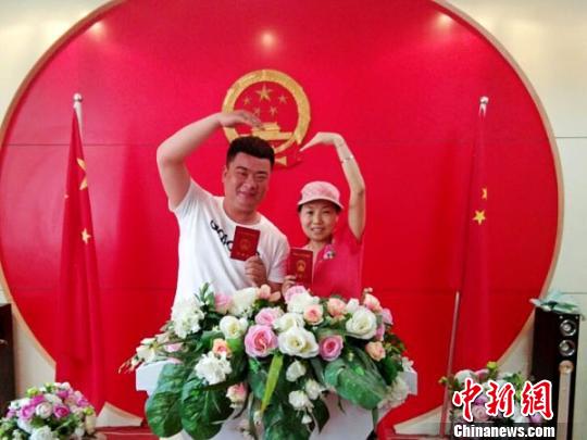 图为拿到结婚证后的新人们摆出姿势秀恩爱。 王秋兰 摄 图为拿到结婚证后的新人们摆出姿势秀恩爱。 王秋兰 摄