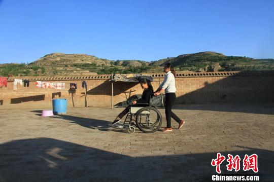 天气晴朗,王宁宁推着妈妈在租住的小院里散步。 李文 摄 天气晴朗,王宁宁推着妈妈在租住的小院里散步。 李文 摄
