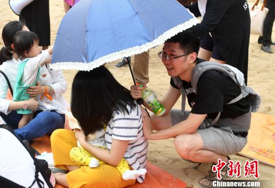 图为丈夫为妻子撑伞。 吕明 摄 图为丈夫为妻子撑伞。 吕明 摄