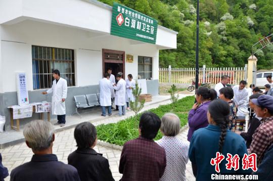 图为白河村村委会院子里,留守村民排队进行体检。 冯志军 摄 图为白河村村委会院子里,留守村民排队进行体检。 冯志军 摄