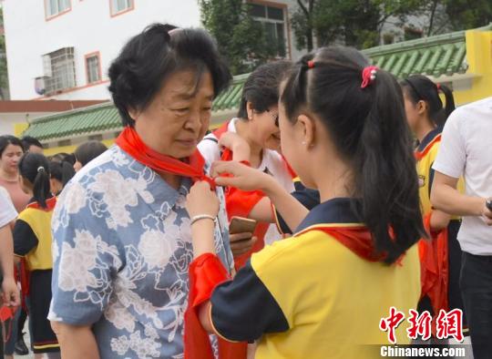 图为“临川八一希望小学”少先队员给贺晓明戴红领巾。 钟欣 摄 图为“临川八一希望小学”少先队员给贺晓明戴红领巾。 钟欣 摄