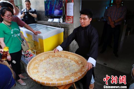 图为廿八都古镇村民王廷高在制作麻饼 王远 摄 图为廿八都古镇村民王廷高在制作麻饼 王远 摄