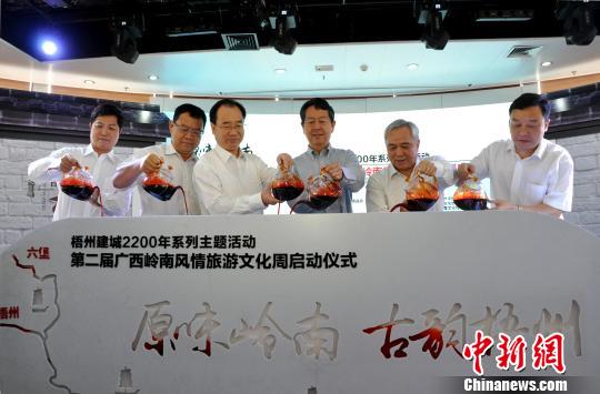图为嘉宾将梧州六堡茶注入启动台,以茶船古道示意图来启动活动周。 黄艳梅 摄 图为嘉宾将梧州六堡茶注入启动台,以茶船古道示意图来启动活动周。 黄艳梅 摄