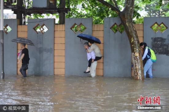 6月10日,南京市雨花台区,市民在水中艰难出行。图片来源:视觉中国 6月10日,南京市雨花台区,市民在水中艰难出行。图片来源:视觉中国