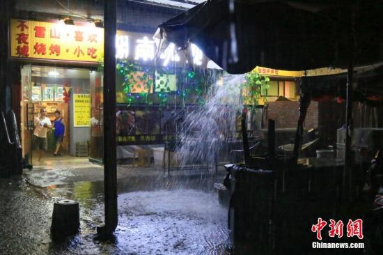 6月10日晚,贵州省雷山县遭受暴雨袭击。图为雷山民众在夜市中避雨。 记者 贺俊怡 摄 6月10日晚,贵州省雷山县遭受暴雨袭击。图为雷山民众在夜市中避雨。 记者 贺俊怡 摄