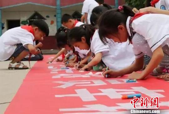 学生在横幅上签字承诺。大安交警 供图 学生在横幅上签字承诺。大安交警 供图