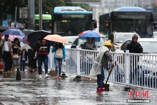 6月12日,贵阳持续降雨造成贵阳市多处路段严重积水,市民出行受阻。图为贵阳市环卫工人清理路面积水。 黄芷昕 摄 6月12日,贵阳持续降雨造成贵阳市多处路段严重积水,市民出行受阻。图为贵阳市环卫工人清理路面积水。 黄芷昕 摄