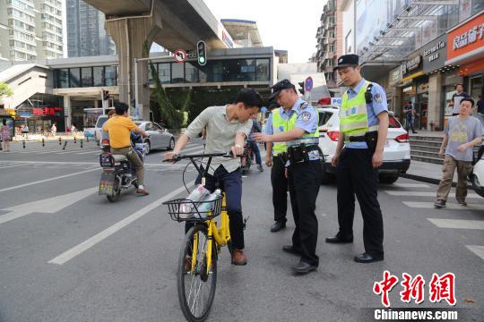 资料图,武汉民警正在盘查骑行共享单车 王威 摄 资料图,武汉民警正在盘查骑行共享单车 王威 摄