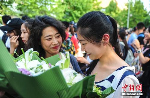 资料图:山东济南众多考生手捧鲜花在家长的簇拥下欢快告别高考。记者 张勇 摄 资料图:山东济南众多考生手捧鲜花在家长的簇拥下欢快告别高考。记者 张勇 摄