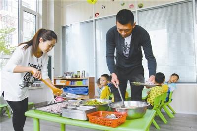 逄秋香、陈亮夫妻俩为幼儿园孩子盛午饭。 逄秋香、陈亮夫妻俩为幼儿园孩子盛午饭。