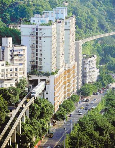 6月21日,在轻轨2号线李子坝站,轻轨列车“穿”居民楼而过。记者 熊明 摄 6月21日,在轻轨2号线李子坝站,轻轨列车“穿”居民楼而过。记者 熊明 摄