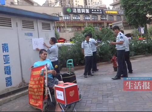 当天经开区城管执法队员在陆富身边举牌被人拍下 当天经开区城管执法队员在陆富身边举牌被人拍下