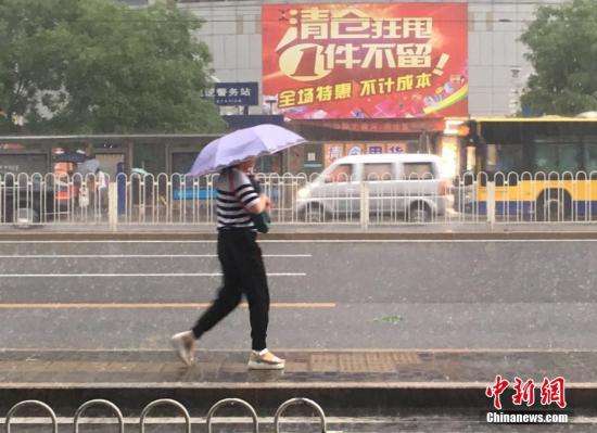 6月23日清晨,北京降雨持续,并出现了短时大雨。据北京市气象局官方微博消息,北京市气象台今日6时发布:今天白天小到中雨并伴有雷电,傍晚局地伴有短时大风或冰雹,北转东风2、3级,最高气温24℃;夜间有雷阵雨,东转北风2、3级,最低气温19℃。图为北京阜成门,一位市民撑伞出行。 记者 富宇 摄 6月23日清晨,北京降雨持续,并出现了短时大雨。据北京市气象局官方微博消息,北京市气象台今日6时发布:今天白天小到中雨并伴有雷电,傍晚局地伴有短时大风或冰雹,北转东风2、3级,最高气温24℃;夜间有雷阵雨,东转北风2、3级,最低气温19℃。图为北京阜成门,一位市民撑伞出行。 记者 富宇 摄