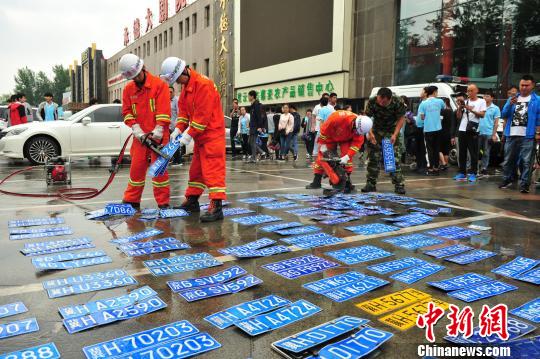 现场销毁假牌100个。 张帆 摄 现场销毁假牌100个。 张帆 摄