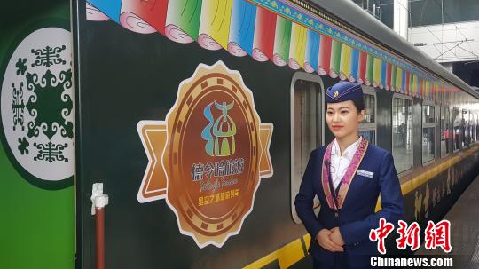 24日,一名列车员在首趟“星空之城”旅游列车前等待旅客上车。 赵凛松 摄 24日,一名列车员在首趟“星空之城”旅游列车前等待旅客上车。 赵凛松 摄