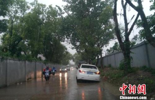 6月23日傍晚,江西省南昌市暴雨如注造成局部道路积水,一辆白色轿车误判路况,陷入水沟无法动弹。 吴艳珍 摄 6月23日傍晚,江西省南昌市暴雨如注造成局部道路积水,一辆白色轿车误判路况,陷入水沟无法动弹。 吴艳珍 摄