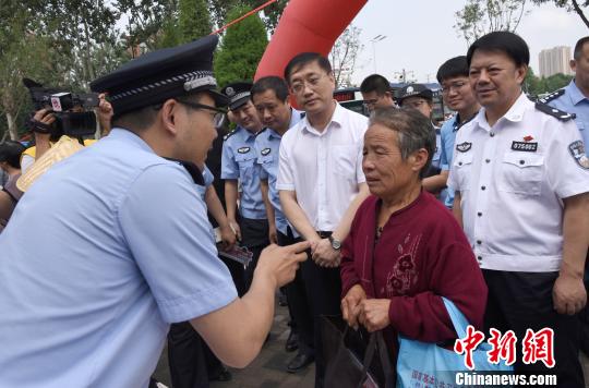 图为治安警察向民众现场讲解如何防范电信诈骗和非法集资。 宋寿涛 摄 图为治安警察向民众现场讲解如何防范电信诈骗和非法集资。 宋寿涛 摄
