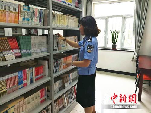 二大队队长夏溪整理书架上的图书 记者 张尼 摄 二大队队长夏溪整理书架上的图书 记者 张尼 摄