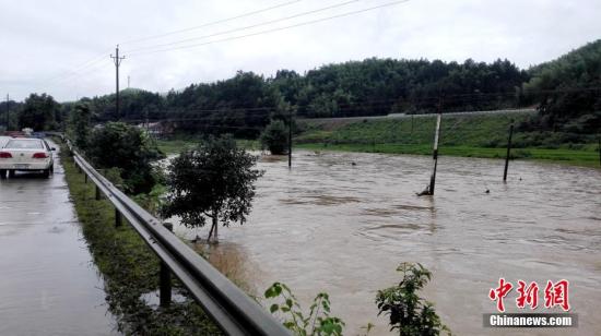 入汛以来,湖南多地先后降下暴雨。6月22日开始,湖南桃江县遭遇今年最强降雨,加之上游水库泄洪,资江桃江段水位连日来持续上涨,造成多地被洪水浸没。6月24日,桃江县警民联动,在洪水肆掠的地段,积极引导人流、车流,一道转移人员、物资,力争将洪灾损失降到最低。图为民警在水淹路段巡逻。 王鹏 摄 入汛以来,湖南多地先后降下暴雨。6月22日开始,湖南桃江县遭遇今年最强降雨,加之上游水库泄洪,资江桃江段水位连日来持续上涨,造成多地被洪水浸没。6月24日,桃江县警民联动,在洪水肆掠的地段,积极引导人流、车流,一道转移人员、物资,力争将洪灾损失降到最低。图为民警在水淹路段巡逻。 王鹏 摄