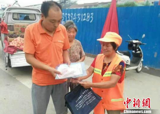 图为6月24日捡到钱包后,汤西兰在原地等候半个多小时,将钱包还给失主。 胡洪涛 摄 图为6月24日捡到钱包后,汤西兰在原地等候半个多小时,将钱包还给失主。 胡洪涛 摄