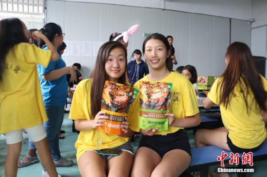 两名美国华裔青少年手捧袋装螺蛳粉合影。 林馨 摄 两名美国华裔青少年手捧袋装螺蛳粉合影。 林馨 摄