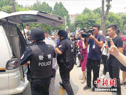 法院执行人员将范某某带走。 记者 张尼 摄 法院执行人员将范某某带走。 记者 张尼 摄