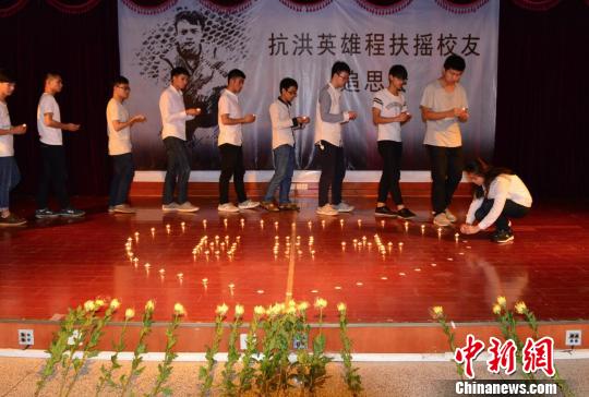 现场师生依次走向英雄遗像前,献上鲜花和蜡烛并深深鞠躬,寄托哀思,以慰英魂。6月29日摄 万福恩 摄 现场师生依次走向英雄遗像前,献上鲜花和蜡烛并深深鞠躬,寄托哀思,以慰英魂。6月29日摄 万福恩 摄