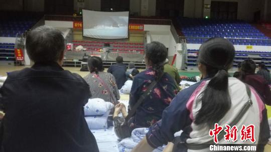 图为安置点受灾群众在看电影。 图为安置点受灾群众在看电影。