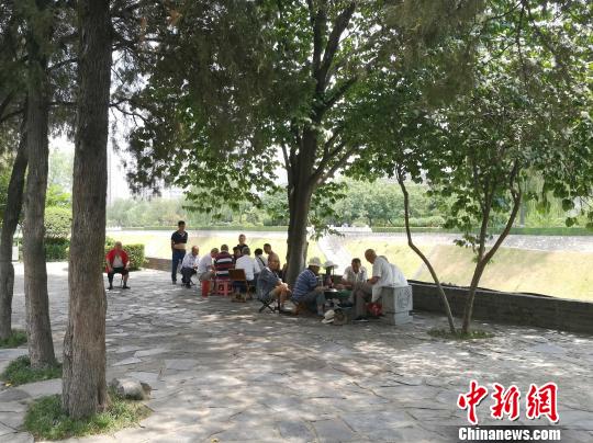 图为高温下民众在阴凉处休闲娱乐。 张枭 摄 图为高温下民众在阴凉处休闲娱乐。 张枭 摄