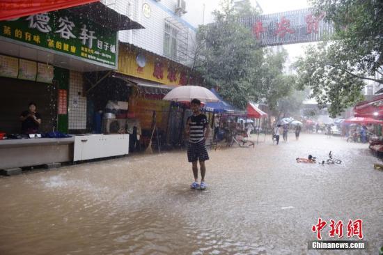 7月1日,一位市民站立在内涝的街道中央。当日,暴雨致长沙城区多处内涝。杨华峰 摄 7月1日,一位市民站立在内涝的街道中央。当日,暴雨致长沙城区多处内涝。杨华峰 摄