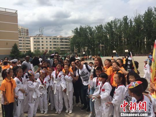图为留学生与陇西县小学生合影互动。 杨娜 摄 图为留学生与陇西县小学生合影互动。 杨娜 摄