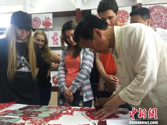 图为留学生参观陇中剪纸作品展。 杨娜 摄 图为留学生参观陇中剪纸作品展。 杨娜 摄