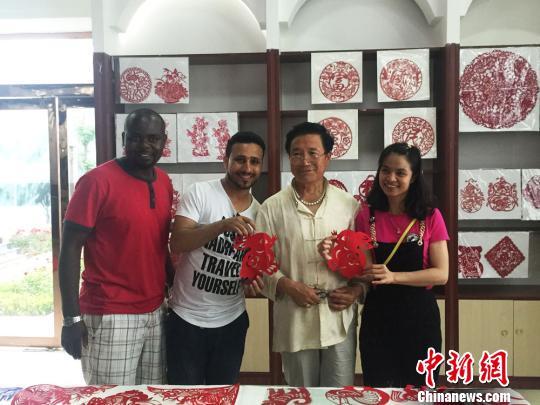 图为留学生现场得到剪纸大师赠送的剪纸作品。 杨娜 摄 图为留学生现场得到剪纸大师赠送的剪纸作品。 杨娜 摄