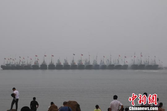 当地渔民驾驶着挂满红绸的渔船开启祭海巡游,驶向主祭坛所在地——海上碑龙王庙。 张西竹 摄 当地渔民驾驶着挂满红绸的渔船开启祭海巡游,驶向主祭坛所在地——海上碑龙王庙。 张西竹 摄