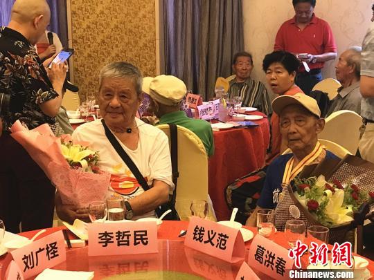 志愿者为抗战老兵献上鲜花。 杨颜慈 摄 志愿者为抗战老兵献上鲜花。 杨颜慈 摄