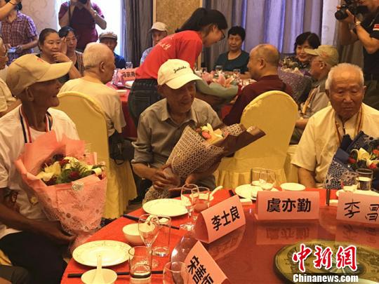志愿者为抗战老兵献上鲜花。 杨颜慈 摄 志愿者为抗战老兵献上鲜花。 杨颜慈 摄