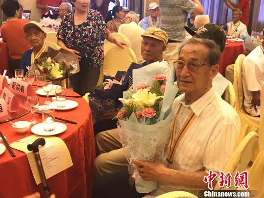 抗战老兵手捧鲜花。 杨颜慈 摄 抗战老兵手捧鲜花。 杨颜慈 摄