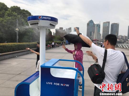 游客纷纷举手感受喷雾的清凉。 王子涛 摄 游客纷纷举手感受喷雾的清凉。 王子涛 摄