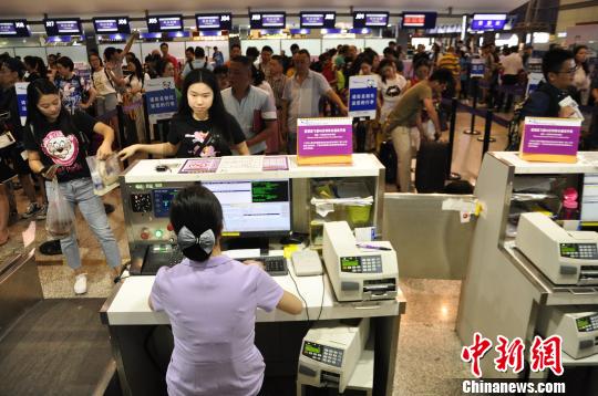 图为旅客在机场大厅值机。 吕俊明 摄 图为旅客在机场大厅值机。 吕俊明 摄