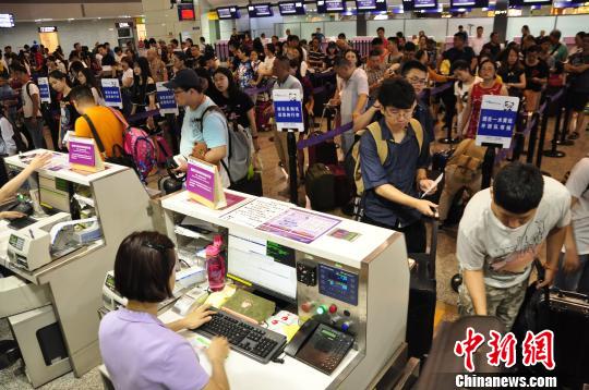 图为旅客排队托运行李。 吕俊明 摄 图为旅客排队托运行李。 吕俊明 摄