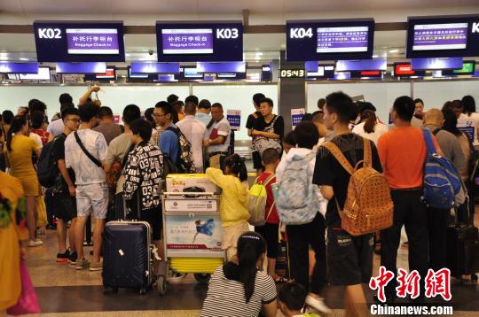 图为旅客排队等待值机。 吕俊明 摄 图为旅客排队等待值机。 吕俊明 摄