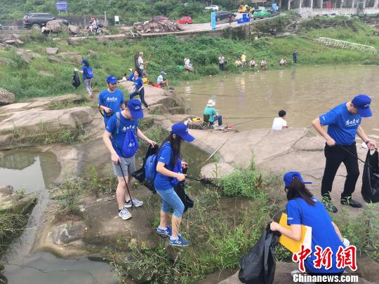图为公益行动参与者们一手拿着大号黑色垃圾袋,一手持垃圾钳,分组到长江岸边捡拾垃圾。 刘贤 摄 图为公益行动参与者们一手拿着大号黑色垃圾袋,一手持垃圾钳,分组到长江岸边捡拾垃圾。 刘贤 摄