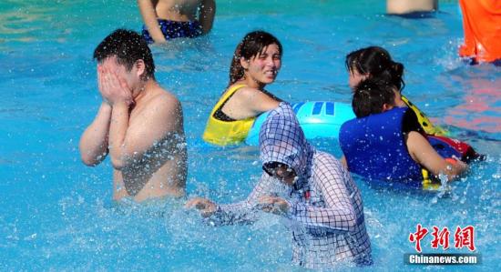 资料图:武汉遭遇“酷暑天”,武汉玛雅水公园里游玩的市民穿着防晒衣在水中玩耍。发 张畅 摄 资料图:武汉遭遇“酷暑天”,武汉玛雅水公园里游玩的市民穿着防晒衣在水中玩耍。发 张畅 摄