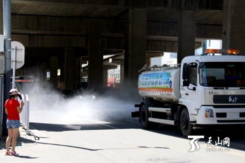 高温天气下,洒水车“出街”降温。 高温天气下,洒水车“出街”降温。
