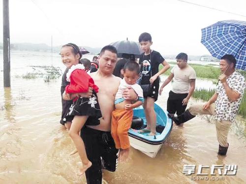 7月1日,唐伟将一船人救到安全区域后,把其中两名小孩抱了下来。随后,他又返回村里救被困群众。受访者供图 7月1日,唐伟将一船人救到安全区域后,把其中两名小孩抱了下来。随后,他又返回村里救被困群众。受访者供图