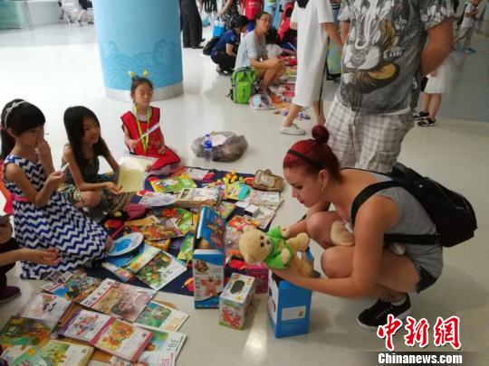 7月15日,由国家游泳中心主办的“爱生活·爱阅读”儿童公益活动在水立方启动。图为孩子们带来自己的闲置物品,在“公益集市”环节通过以物易物或是现金交易来筹集善款。水立方供图 7月15日,由国家游泳中心主办的“爱生活·爱阅读”儿童公益活动在水立方启动。图为孩子们带来自己的闲置物品,在“公益集市”环节通过以物易物或是现金交易来筹集善款。水立方供图